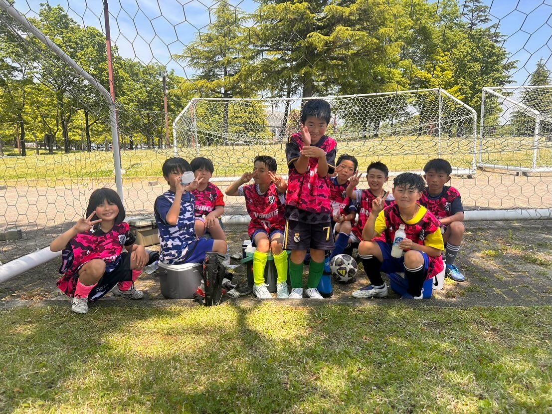 ゴール前でピースする幼児・低学年の子どもたち