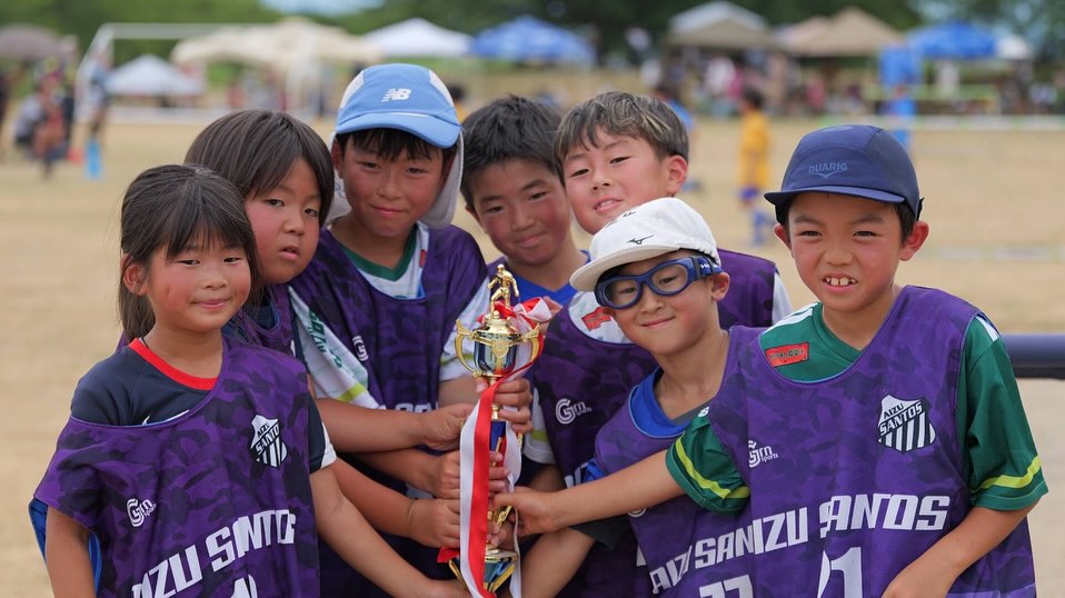 優勝トロフィーを囲んで笑い合う会津サントスFCの子どもたち